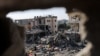 Palestinci stoje među ruševinama kuća uništenih u izraelskom napadu, usred privremenog primirja između Hamasa i Izraela, u Kan Younisu u južnom pojasu Gaze 24. novembra 2023.