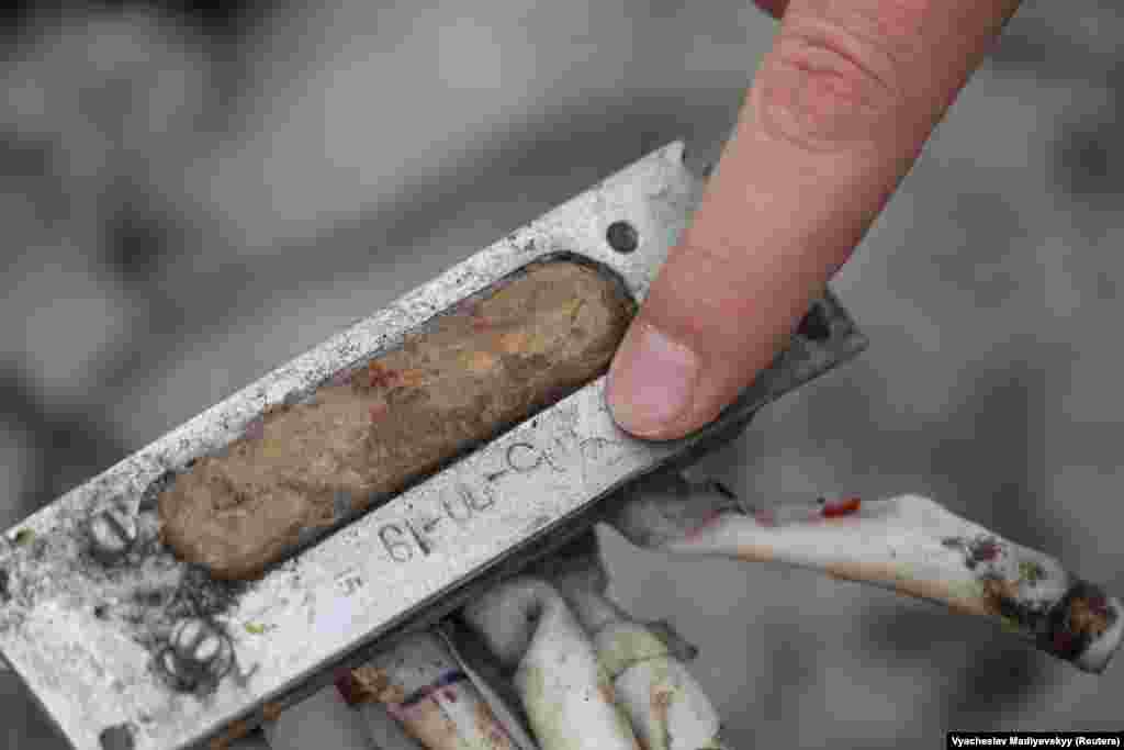 Ciubenko arată un înscris de pe un fragment de rachetă care nu pare a fi nici în alfabet chirilic, nici în alfabet latin.