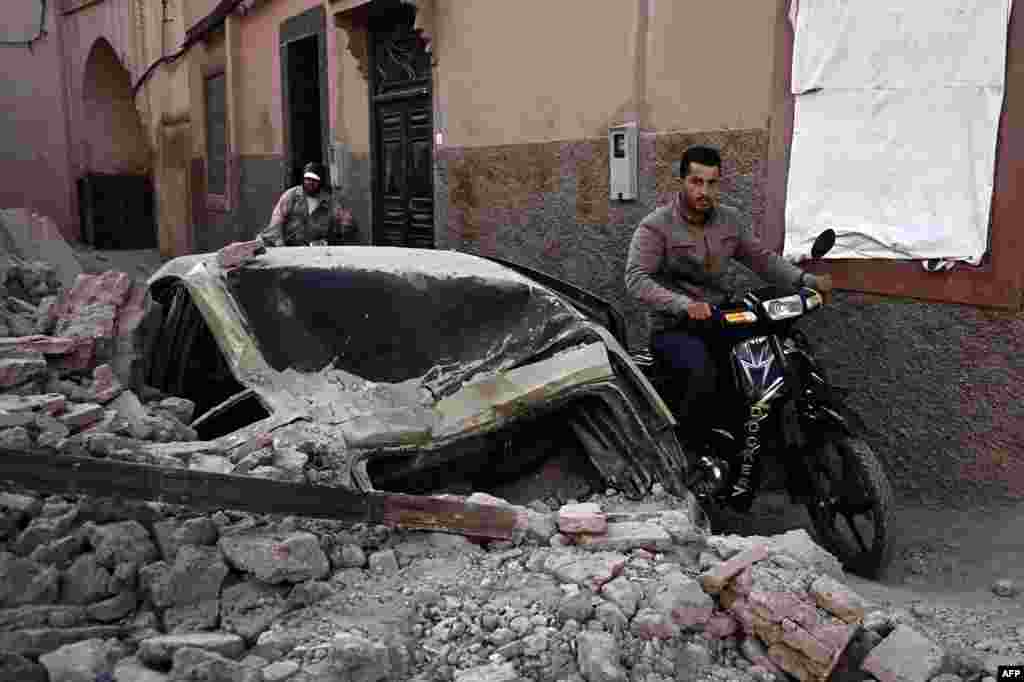 Muškarac vozi motocikl pored ruševina u starim četvrtima Marakeša 10. septembra 2023., dva dana nakon što je zemlju pogodio razorni potres magnitude 6,8 stepeni po Rihteru.