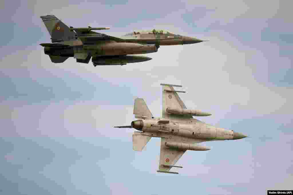 Avioane de vânătoare F-16 ale Armatei române survolează, la inaugurare, centrul de antrenament F-16 la baza militară aeriană Baza 86, în afara orașului Fetești, România, pe 13 noiembrie, 2023. Baza de antrenament situată în sud-estul României are ca scop creșterea interoperabilității între aliații NATO și o mai bună poziționare a alianței militare „pentru a face față provocărilor complexe” din Europa de Est și din regiunea Mării Negre, a declarat Ministerul român al Apărării.