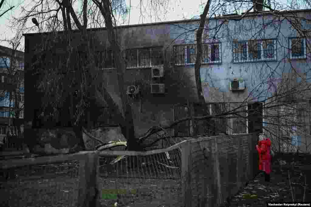 Un localnic se uită la distrugerile provocate unei clădiri de locuit.