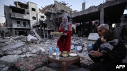 Një familje palestineze duke ngrënë iftarin mes rrënojash, më 11 mars 2024.
