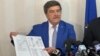 Toni Greblă, președintele Autorității Electorale Permanente din România, arată un model de buletin de vot care va fi folosit la alegerile din 9 iunie