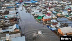 Pogled dronom prikazuje kamion koji se vozi poplavljenom ulicom u naselju Zarečnoje, oblast Orenburg, Rusija, 11. aprila 2024.