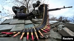 Un militar ucrainean încarcă muniție pentru mitraliera unui tanc, în timpul unui antrenament militar în apropierea liniei de front, în regiunea Zaporojie, 29 martie 2023.