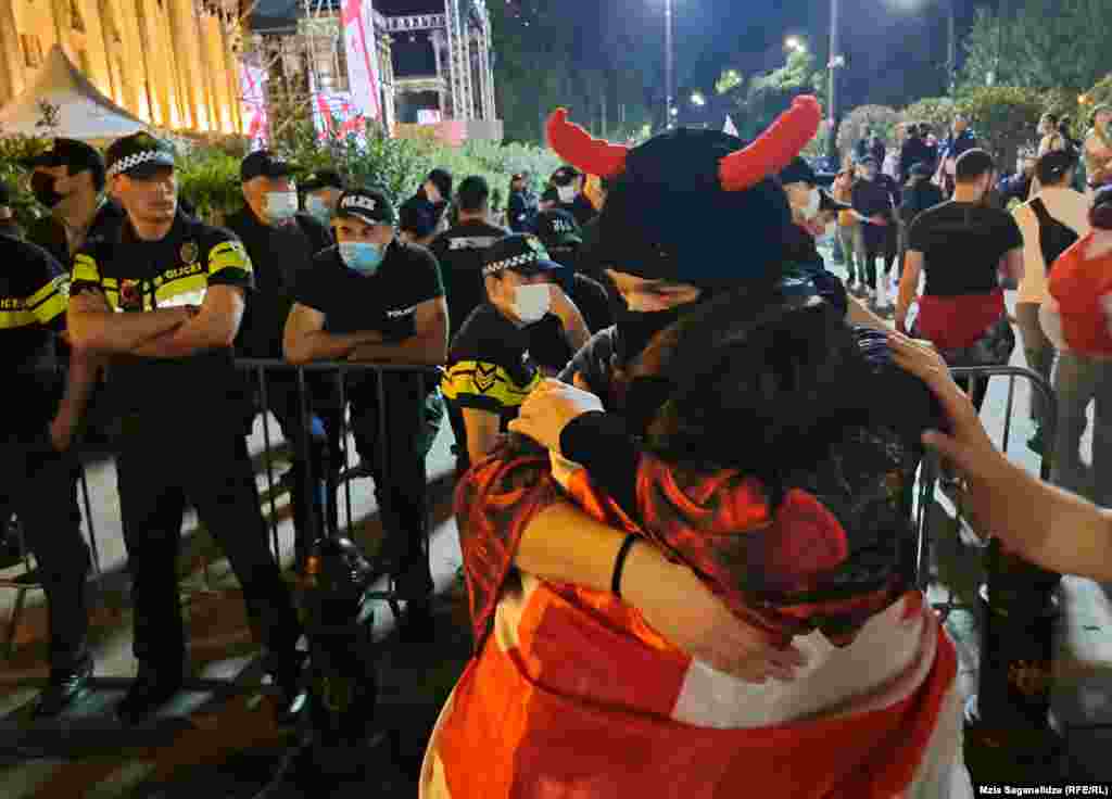 People embrace beside a security cordon near the parliament building. The ruling Georgian Dream party announced its plans to reintroduce the bill after a previous version was dropped in 2023. This new version omits the phrase &quot;foreign agent.&quot; &nbsp;