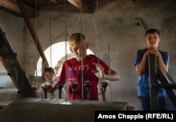 Băieții din Sarichioi acționează pârghiile care bat clopotele uneia dintre bisericile lipovenești din sat.