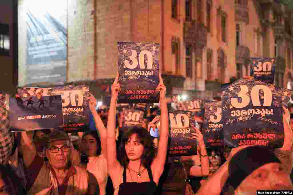 Protesters hold up signs that say, &quot;Yes to Europe&quot; and &quot;No to Russian law.&quot;