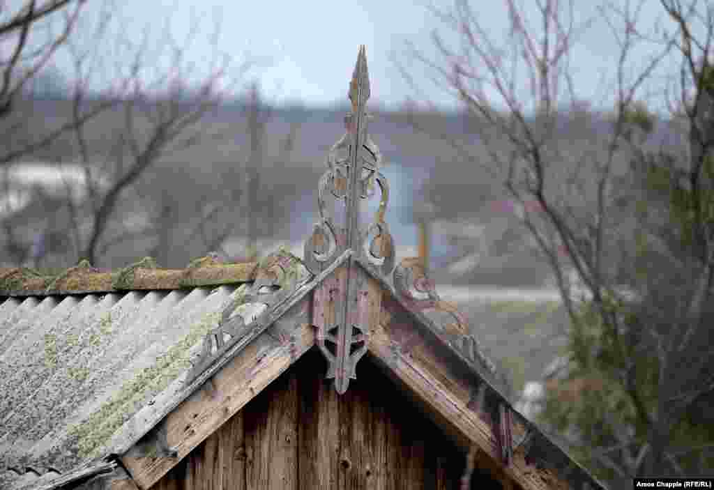 Se spune că „șerpii” care se încolăcesc de o parte și de alta a ornamentului principal ar proteja casa de spiritele rele.