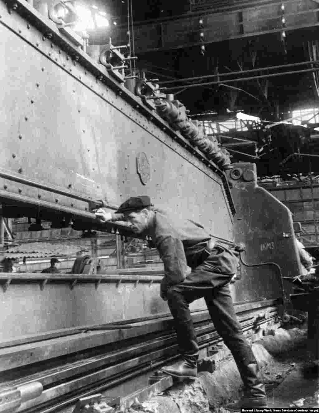 Un mecanic verifică asamblarea echipamentelor grele în timpul lucrărilor de restaurare la uzina constructoare de mașini Stalin din Kramatorsk, la sfârșitul anilor 1940. Potrivit unui raport desecretizat al CIA din 1952, fabrica a fost „avariată în proporție de 80% în timpul războiului”, și și-a reluat funcționarea completă în mai 1949.