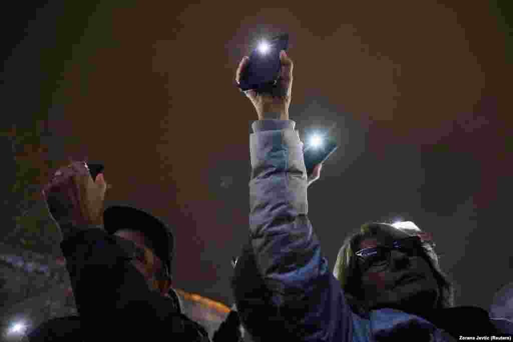 Oamenii &bdquo;contribuind&rdquo; la miting cu luminile telefonului mobil.&nbsp;
