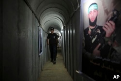 În această fotografie din 2016, un bărbat palestinian pășește într-un tunel folosit pentru exerciții militare în timpul unei expuneri de arme la o tabără de vară pentru tineri condusă de Hamas din orașul Gaza.