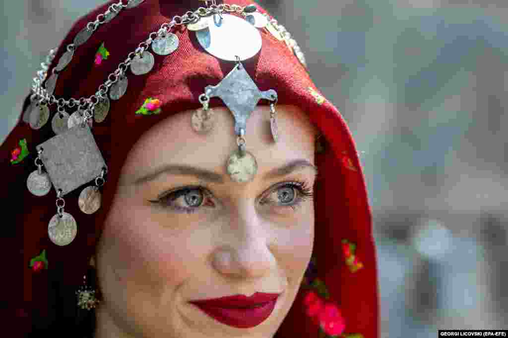 Žena odjevena u tradicionalnu odjeću posmatra svečanosti.