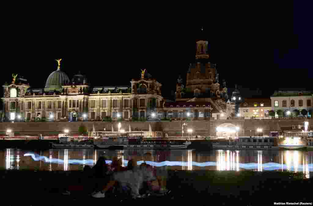 Iată cum arăta malul râului din Dresda în seara de 22 august. Luminile pun de obicei în evidență arhitectura orașului din estul Germaniei, dar în ultimele săptămâni linia orizontului a devenit întunecată. 