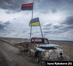 Drapelul Ucrainei și cel al armatei ucrainene de insurgență (stânga) fotografiate în apropiere de linia frontului în conflictul dintre forțele ucrainene și separatiștii pro-ruși în 2019