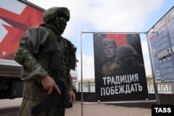 Un soldat stă în fața unui birou mobil de recrutare al armatei ruse în Rostov pe Don, Rusia, în septembrie 2022.