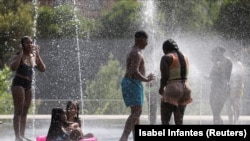 Ljudi se hlade u fontani u Rio Parku tokom toplotnog vala u Madridu, Španija 14. juli 2022. 