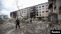 Voluntarii britanici Chris și Dave caută localinici pentru a-i evacua dintr-un bloc distrus de bombardamente, în Bahmut, regiunea Donețk, 5 ianuarie 2023