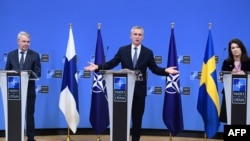 Jens Stoltenberg NATO-főtitkár (középen), Pekka Haavisto finn (balra) és Ann Linde svéd külügyminiszter (jobbra) közös sajtótájékoztatót tart megbeszélésük után a brüsszeli NATO-székházban 2022. január 24-én