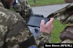 Un grup de soldați exersează la școala de drone Kruk, urmărind comenzile de pilotare a unei drone.