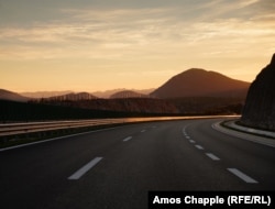 Një pjesë e zbrazët e autostradës gjatë perëndim të diellit