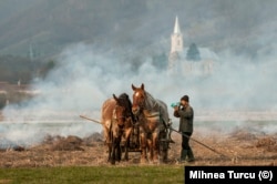 Un sătean din județul Maramureș bea în timp ce își pregătește pământul pentru primăvară, în 2010.