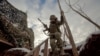 Un militar ucrainean coboară treptele în tranșee de pe prima linie a frontului în fața separatiștilor susținuți de Rusia în regiunea Donețk pe 22 ianuarie.