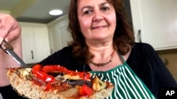Tiziana di Costanzo, suosnivačica firme Horizon Insects, u svojoj londonskoj kuhinji drži krišku pizze napravljenu od praha mljevenih cvrčaka. 