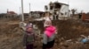 Dy fëmijë ukrainas qëndrojnë pranë një vendi që është goditur nga sulmet ruse në periferi të Kievit. Fotografi ilustruese. 