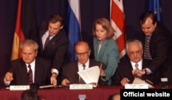 Președintele sârb, Slobodan Milosevic (stânga), președintele bosniac, Alija Izetbegovic (centru), și președintele croat, Franjo Tudjman (dreapta), parafează acordul de pace după 21 de zile de discuții la Wright-Patterson Air Force Base din Dayton, Ohio, la 21 noiembrie 1995.