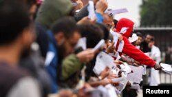Izbjeglice pokazuju svoje papire u glavnom prihvatnom centru za tražioce azila, u Ter Apelu, Holandija, 17. avgusta 2022.