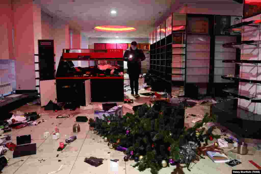 Një pemë Krishtlindjesh e rrëzuar brenda një dyqani të grabitur, Almati.