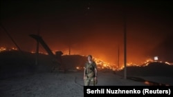 Ukrajinski vojnik prolazi pored zapaljenog silosa za žito koji je više puta granatiran tokom ruske invazije na Ukrajinu, u oblasti Donjecka 31. maja.