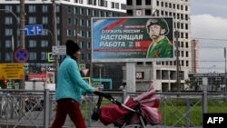 Un panou publicitar din Sankt Petersburg care promovează serviciul militar cu imaginea unui soldat și un slogan care spune: "A servi Rusia este o slujbă adevărată".