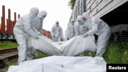 Ukrainasit duke bartur trupat e vdekur të ushtarëve rusë. Fotografi nga arkivi.