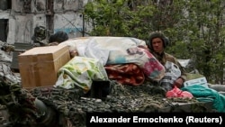 Detalj s Rojtersove fotografije na kojoj se vide ruski vojnici na vrhu oklopnog vozila u ukrajinskom gradu Popasna s predmetima za domaćinstvo za koje Alina Korenjuk kaže da su ukradene iz njene kuće.