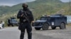 Një pjesëtar i Njësisë Speciale në Policinë e Kosovës, duke u kujdesuar për sigurinë, pas bllokimit të rrugës që çon në pikën kufitare në Jarinjë. Shtator 2021.