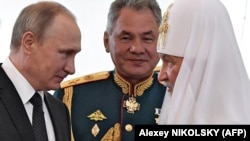 Vladimir Putin, ministrul Apărării, Serghei Șoigu, și patriarhul Kirill al Moscovei, la Sankt Petersburg, 30 iulie 2017.