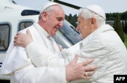 „Papa emerit” Benedict al XVI-lea (dreapta) îl salută pe Papa Francisc, martie 2013.