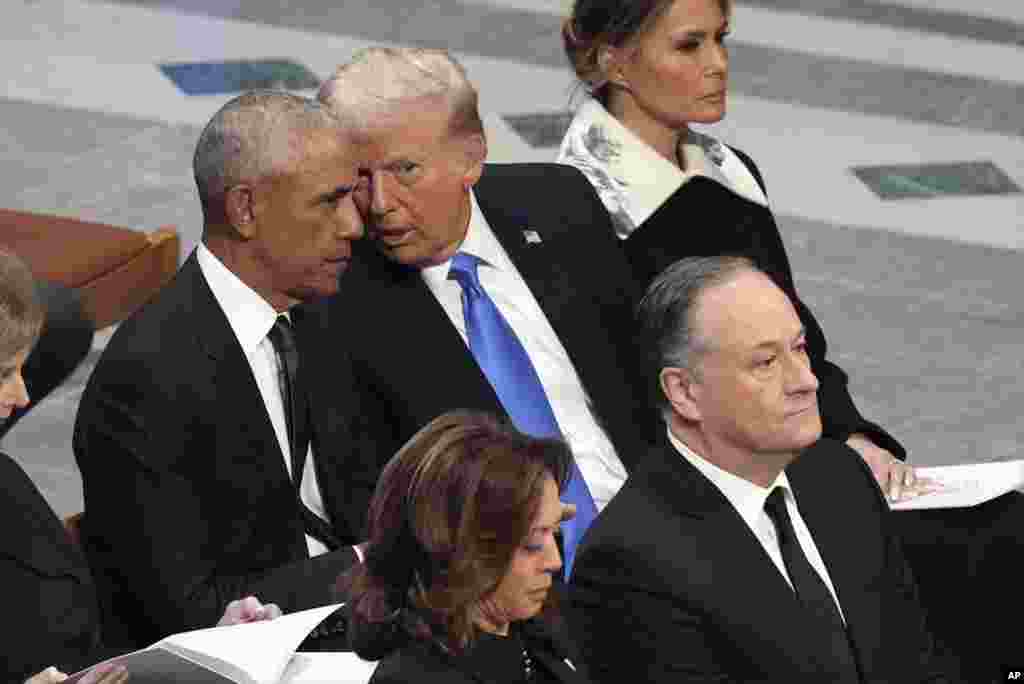 Ish-presidenti Barack Obama bisedon me presidentin e zgjedhur Donald Trump, derisa Melania Trump dëgjon, dhe, në të njëjtën kohë, nënpresidentja Kamala Harris dhe bashkëshorti i saj, Doug Emhoff, mbërrijnë, para funeralit shtetëror të ish-presidentit Jimmy Carter në Katedralen Kombëtare të Uashingtonit, 9 janar 2025.