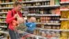 Egy kétgyermekes édesanya vásárol az Auchan budaörsi áruházában 2017. május 5-én. (A kép illusztráció)