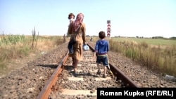 Мајка и нејзините деца, фотографирани во 2015 година, пешачат преку границата од Србија кон Унгарија.