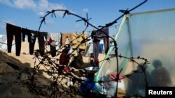 Një familje palestineze, e zhvendosur në një tendë në Rafah, qytet i Rripit të Gazës në kufi me Egjiptin.
