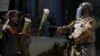 Протестувальник протягує квіти бійцю Національної гвардії, який стоїть поблизу офісу окружного прокурора в місті Лос-Анджелесі. 3 червня 2020 року (Фото AP/Damian Dovarganes)