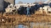 Полицейский стоит возле рухнувшего дома в новом микрорайоне Бесоба. Караганда, 7 апреля 2012 года. 
