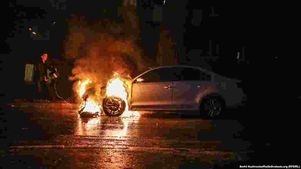 O mașină cu numere diplomatice ruse arde la Kiev, Ucraina, pe 25 noiembrie. Protestatarii furioși au arundat cu fumigene în afara Ambasadei Rusiei, după ce forțele rusești au sechestrat trei nave ucrainene și au reținut 24 de marinari ucraineni în strâmtoarea Kerci. (Serhi Nuzhnenko, RFE/RL)