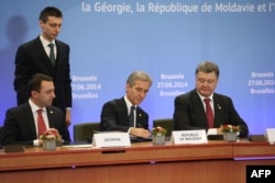 Прем'єр-міністр Грузії Іраклі Гарібашвілі (ліворуч), прем'єр-міністр Молдови Юріє Лянке (посередині) та президент України Петро Порошенко (праворуч) під час підписання угоди про асоціацію з ЄС. Брюссель, 27 червня 2014 року