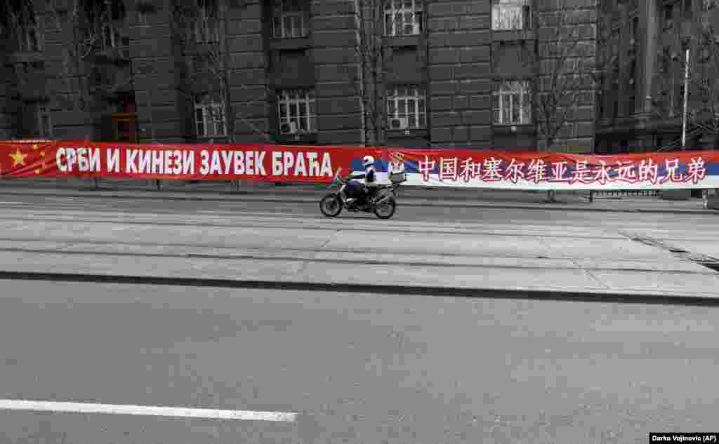 Un banner în centrul Belgradului, pe 18 aprilie, pe care scrie: „Sârbi și chinezi, frați pentru totdeauna." Ognjen Zoric, un jurnalist sârb al Serviciului Balcanic al RFE / RL, spune că există o simpatie față de China în rândul publicului sârb, în special după bombardamentele NATO din Iugoslavia, în 1999, față de care China s-a opus, dar afișajele ar putea avea drept scop atragerea atenției UE. Din 2011, Serbia a început negocierile pentru aderarea la UE.