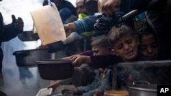 Palestinezë duke pritur për të marrë ushqim falas në Rafah, Rripi i Gazës, më 16 shkurt 2024.