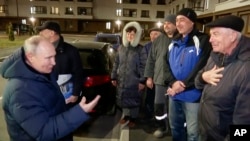 Președintele rus Vladimir Putin discută cu locuitori selectați cu grijă, în Mariupol, regiunea ucraineană Donețk controlată de Rusia, 19 martie. 
